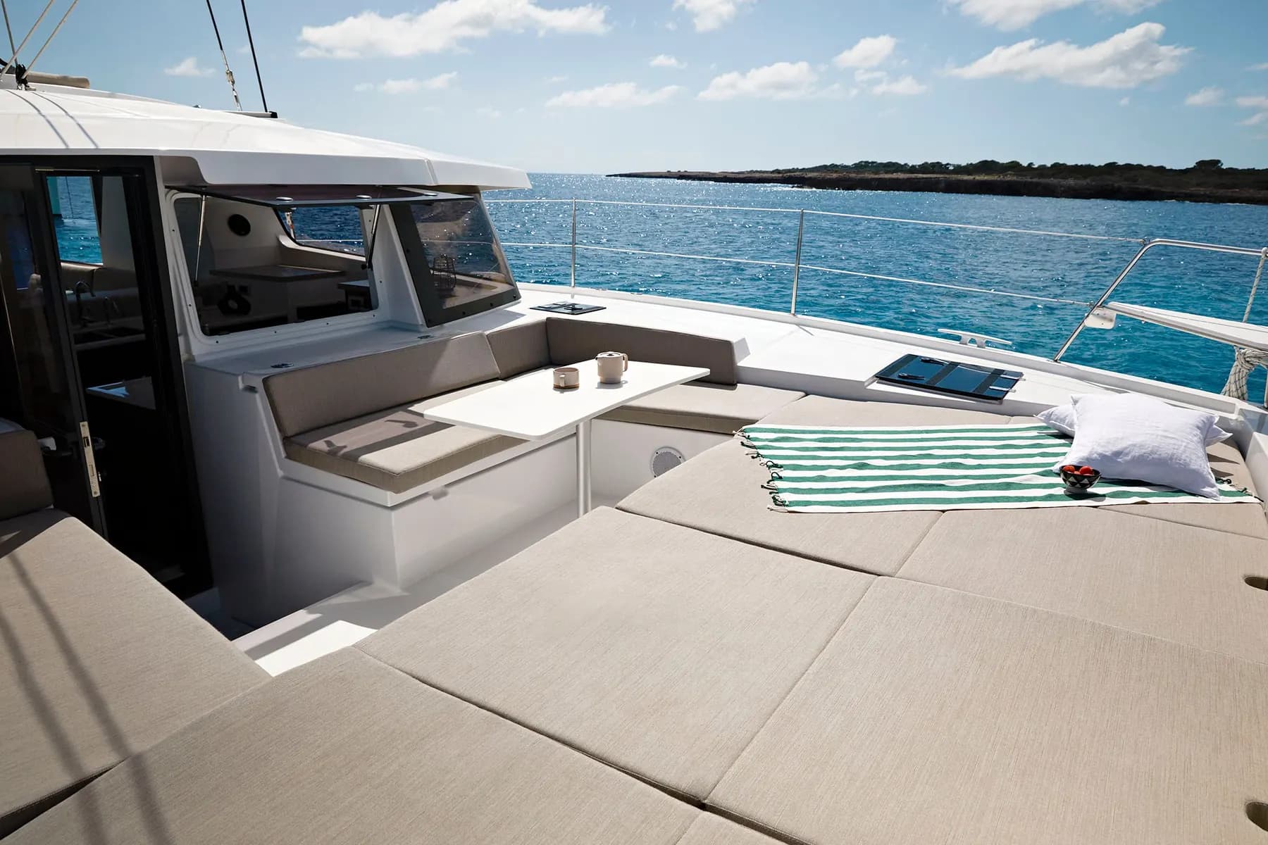 Forward deck sunbed and forward cockpit of a Bali 4.2 catamaran, looking out to sea