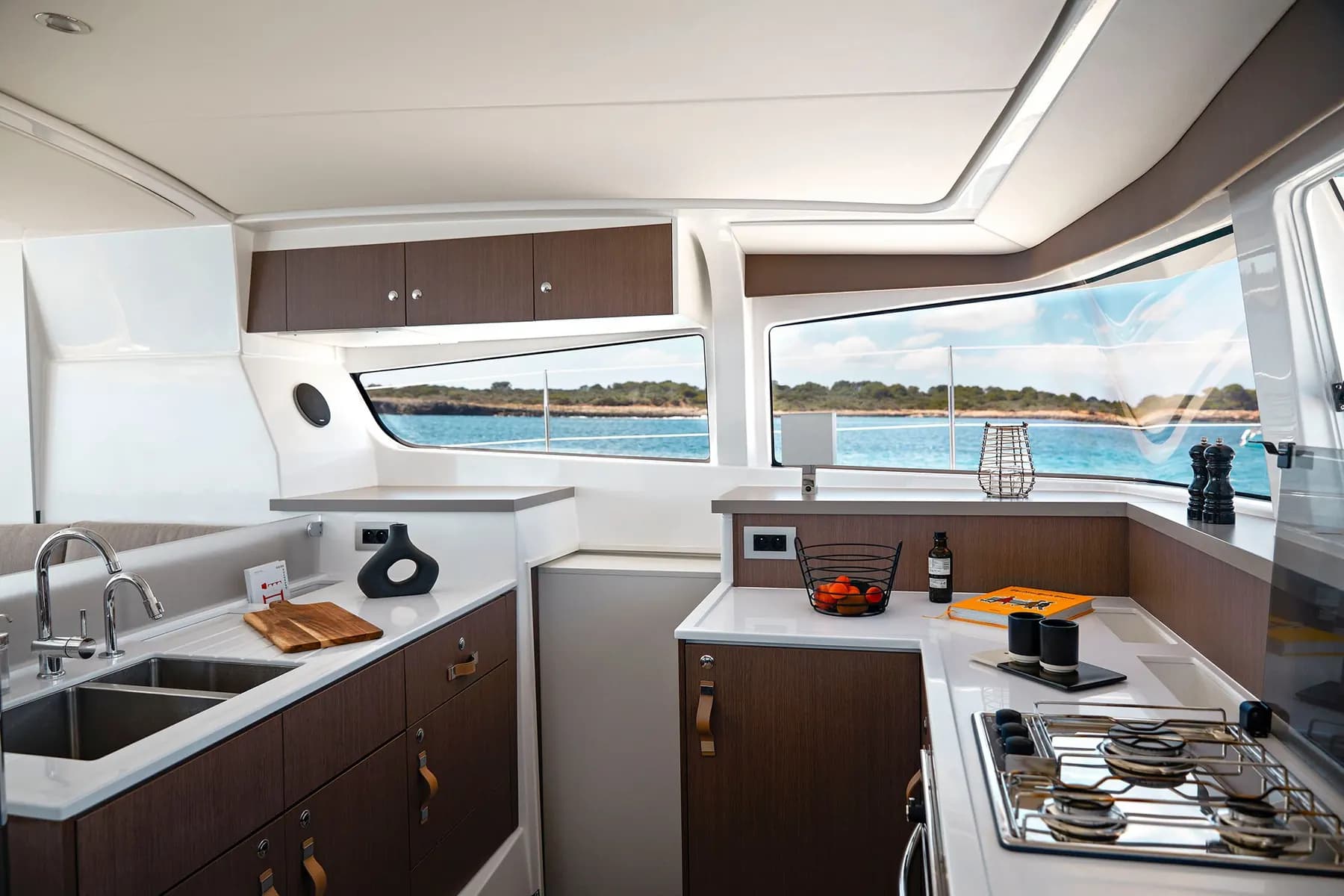 Galley of a Bali 4.2 catamaran with a double sink, a gas hob and wide windows onto the sea